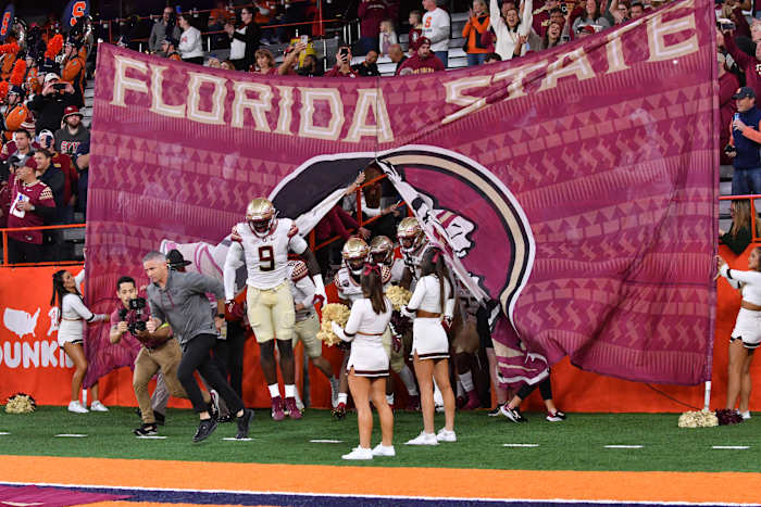Syracuse, New York, USA; Florida State Seminoles head coach Mike Norvell (left) and defensive end Derrick McLendon II (9) lead their team onto the field before a game against the Syracuse Orange at JMA Wireless Dome.